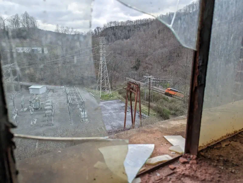 The view of a freight train passing an abandoned power plant deep in Appalachia