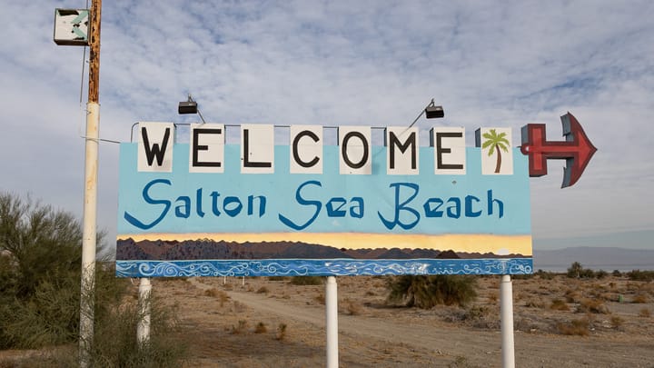 An old sign welcoming you to the Salton Sea Beach in California.